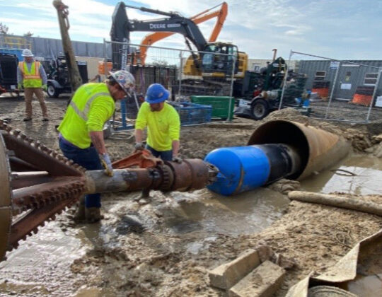Laborers work to detach one of the two 42-inch conduits from the drill string following its successful installation beneath Covell’s Beach and the Nantucket Sound seabed.