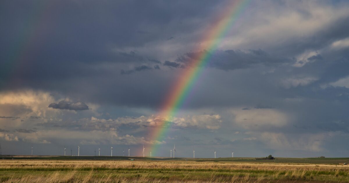 Rainbow with wind turbines in background